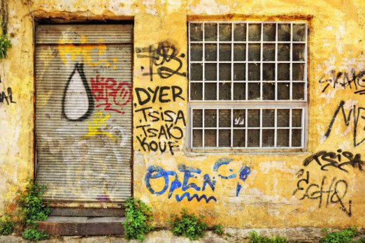 An old rusted roller door, covered in graffiti