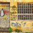 An old rusted roller door, covered in graffiti